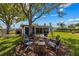 Expansive backyard with a fire pit area surrounded by mature trees, creating a serene outdoor oasis for relaxing and gathering at 5704 2Nd Avenue Nw Dr, Bradenton, FL 34209