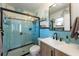 Aqua tiled bathroom with glass shower door, decorative tile accents, and modern vanity at 5704 2Nd Avenue Nw Dr, Bradenton, FL 34209