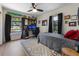 Modern bedroom features sleek black curtains, a ceiling fan, and a dedicated workspace, creating a comfortable retreat at 5704 2Nd Avenue Nw Dr, Bradenton, FL 34209