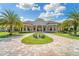 Beautiful clubhouse exterior featuring lush landscaping, palm trees, and an elegant circular drive at 5810 Brandon Run, Bradenton, FL 34211