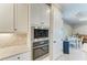 Close-up of modern kitchen appliances, white cabinets, tile backsplash, and stylish lighting features at 5810 Brandon Run, Bradenton, FL 34211