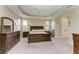 Spacious main bedroom with tray ceiling, carpeted floor, and dark wood furniture at 5810 Brandon Run, Bradenton, FL 34211
