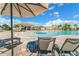 Relaxing poolside view with lounge chairs, umbrellas, and clear blue water on a sunny day at 5810 Brandon Run, Bradenton, FL 34211