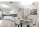 Open-concept kitchen and dining area with modern white cabinetry and glass dining table at 6418 Rosefinch Ct # 103, Lakewood Ranch, FL 34202