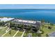 Stunning aerial view of a waterfront complex with lush landscaping, a private beach, and serene water views at 6500 Flotilla Dr # 126, Holmes Beach, FL 34217