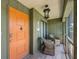 Inviting front porch with seating, nautical decor, and a vibrant orange entry door at 6500 Flotilla Dr # 126, Holmes Beach, FL 34217