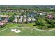 Aerial view of homes, a golf course, and a pond surrounded by lush greenery at 6642 Oakland Hills Dr, Lakewood Ranch, FL 34202