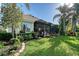 Lush backyard featuring a screened-in patio, well-manicured lawn, and beautiful landscaping at 6642 Oakland Hills Dr, Lakewood Ranch, FL 34202
