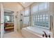 Bathroom featuring a walk-in glass shower, and a soaking tub with glass block window at 6642 Oakland Hills Dr, Lakewood Ranch, FL 34202