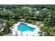 Aerial view of the community pool featuring ample seating, a pergola, and lush tropical landscaping at 6642 Oakland Hills Dr, Lakewood Ranch, FL 34202