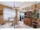 Cozy dining area with a glass table, decorative hutch, large windows with sheer curtains and a ceiling fan for added comfort at 6642 Oakland Hills Dr, Lakewood Ranch, FL 34202