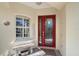 Inviting front entrance with a decorative red door, window, and bench seating area at 6642 Oakland Hills Dr, Lakewood Ranch, FL 34202