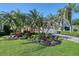 Beautiful home exterior featuring a vibrant yard, complemented by palm trees and a spacious two car garage at 6642 Oakland Hills Dr, Lakewood Ranch, FL 34202