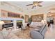 Bright living room with fireplace and comfortable couches, with a ceiling fan and large artwork at 6642 Oakland Hills Dr, Lakewood Ranch, FL 34202