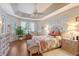 Bright and airy main bedroom with tray ceilings, hardwood floors, and many windows at 6642 Oakland Hills Dr, Lakewood Ranch, FL 34202
