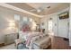 Spacious main bedroom with hardwood floors, tray ceilings, and a doorway to the bathroom at 6642 Oakland Hills Dr, Lakewood Ranch, FL 34202