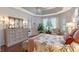 Main bedroom with hardwood floors, bench seating, and bedside tables with lamps at 6642 Oakland Hills Dr, Lakewood Ranch, FL 34202