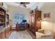 Home office boasts hardwood floors, large windows with shutters, and a decorative armoire at 6642 Oakland Hills Dr, Lakewood Ranch, FL 34202