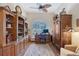 Spacious home office featuring custom wooden shelves, a ceiling fan, and a decorative rug at 6642 Oakland Hills Dr, Lakewood Ranch, FL 34202