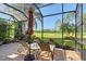 Relaxing screened-in patio with an umbrella, featuring comfortable seating and golf course views at 6642 Oakland Hills Dr, Lakewood Ranch, FL 34202