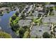 Aerial view of community tennis courts, parking and adjacent lake offer recreational amenities in a lush environment at 6642 Oakland Hills Dr, Lakewood Ranch, FL 34202
