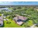 Expansive aerial view of the house surrounded by lush landscaping, a lake, and a nearby golf course at 7408 S Serenoa Dr, Sarasota, FL 34241