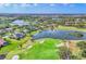 Scenic aerial shot showcasing a golf course with bunkers and a serene lake surrounded by lush greenery and residential houses at 7408 S Serenoa Dr, Sarasota, FL 34241