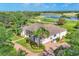 Aerial view of a single-story home, lush landscaping, and brick driveway situated on the golf course at 7408 S Serenoa Dr, Sarasota, FL 34241