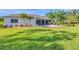 Landscaped backyard featuring a brick patio, screened-in porch, and lush green lawn at 7408 S Serenoa Dr, Sarasota, FL 34241