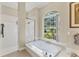 Bright bathroom with a garden view from the soaking tub and tiled shower at 7408 S Serenoa Dr, Sarasota, FL 34241