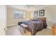 Cozy bedroom with modern ceiling fan, patterned bedspread, and neutral tiled flooring at 7408 S Serenoa Dr, Sarasota, FL 34241
