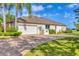 Charming home featuring a brick driveway, a two-car garage, and well-maintained landscaping at 7408 S Serenoa Dr, Sarasota, FL 34241