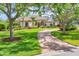 Charming single-story home featuring a well-manicured lawn, beautiful landscaping, and a circular brick driveway at 7408 S Serenoa Dr, Sarasota, FL 34241