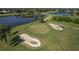 Scenic aerial view of the golf course featuring lush greenery, sand traps, and a tranquil lake at 7408 S Serenoa Dr, Sarasota, FL 34241