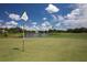 Picturesque golf course view, featuring a putting green, lake, and surrounding mature trees at 7408 S Serenoa Dr, Sarasota, FL 34241