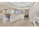 Open kitchen with white cabinetry, a breakfast bar, and dining area access at 7408 S Serenoa Dr, Sarasota, FL 34241