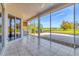 Screened lanai with tile flooring providing serene outdoor views of the landscaped grounds at 7408 S Serenoa Dr, Sarasota, FL 34241