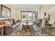 Bright living room with leather sofa, zebra print chairs, and access to an outdoor patio at 7408 S Serenoa Dr, Sarasota, FL 34241