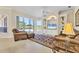 Inviting living room with comfortable leather seating, built-in shelving, and scenic views through large windows at 7408 S Serenoa Dr, Sarasota, FL 34241