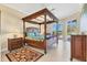 Elegant main bedroom with a canopy bed, tiled flooring, and access to the outdoor patio at 7408 S Serenoa Dr, Sarasota, FL 34241