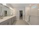 Bathroom featuring double vanity sinks, a glass-enclosed shower, and access to a well-organized walk-in closet at 8110 Trimbelle Ter, Parrish, FL 34219