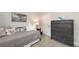 Bedroom with a full size bed with an art image above and a dark grey dresser along a wall at 8110 Trimbelle Ter, Parrish, FL 34219