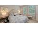 Bedroom with a queen bed, natural light, and a view of green foliage, creating a tranquil and inviting space at 8110 Trimbelle Ter, Parrish, FL 34219
