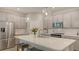 A modern kitchen features stainless steel appliances, pendant lighting, light gray cabinetry, and an island with seating at 8110 Trimbelle Ter, Parrish, FL 34219