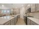 The expansive kitchen boasts stainless steel appliances, light gray cabinetry, and a large island with sink and modern faucet at 8110 Trimbelle Ter, Parrish, FL 34219