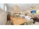 Open-concept living room with hardwood floors, modern ceiling fan, and seamless flow into dining and kitchen areas at 8110 Trimbelle Ter, Parrish, FL 34219