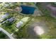 Aerial view of home with pool and backing on to a pond, surrounded by lush landscaping at 8223 Snowy Egret Pl, Bradenton, FL 34202