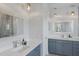 Bathroom with double sink vanity, decorative mirrors, modern lighting, and tiled floors at 8223 Snowy Egret Pl, Bradenton, FL 34202