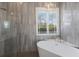 Spa-like bathroom with a freestanding tub, large window, and a walk-in shower at 8223 Snowy Egret Pl, Bradenton, FL 34202