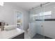 Bright bathroom featuring a walk-in shower, modern vanity, and a door leading to the backyard at 8223 Snowy Egret Pl, Bradenton, FL 34202